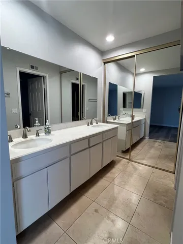 a bathroom with a double vanity sink and a mirror