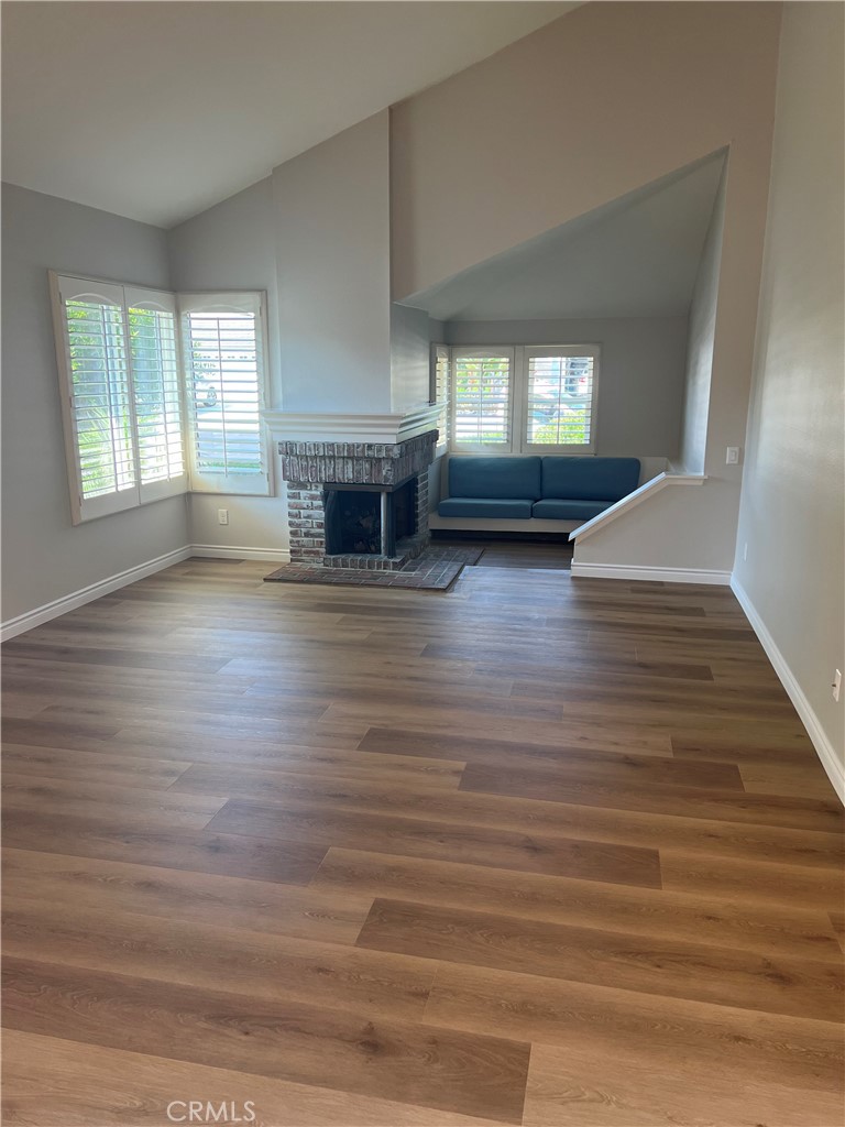 26 Alderbrook Irvine, CA 92604 - Photo 4 of 16 an empty room with wooden floor fireplace and windows