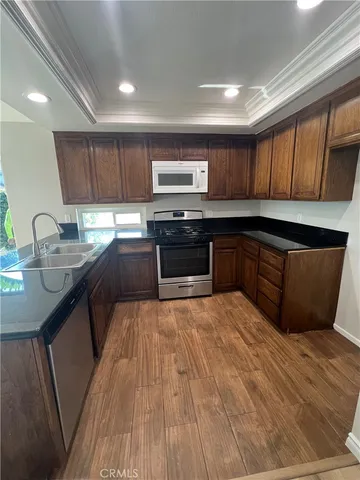 a kitchen with stainless steel appliances kitchen island granite countertop a sink stove and cabinets