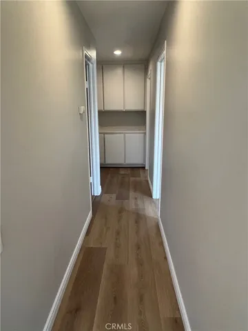 a view of a hallway with wooden floor