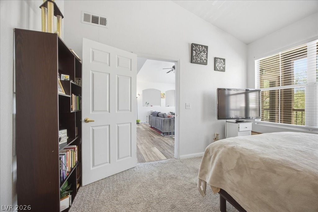 10550 West Alexander Road, Unit 2164 Las Vegas, NV 89129 - Photo 14 of 27 A restful bedroom with soft carpet, high ceilings, and a wide window offering abundant natural light.