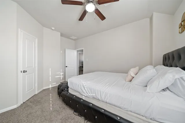 a bedroom with a bed and painting on the wall