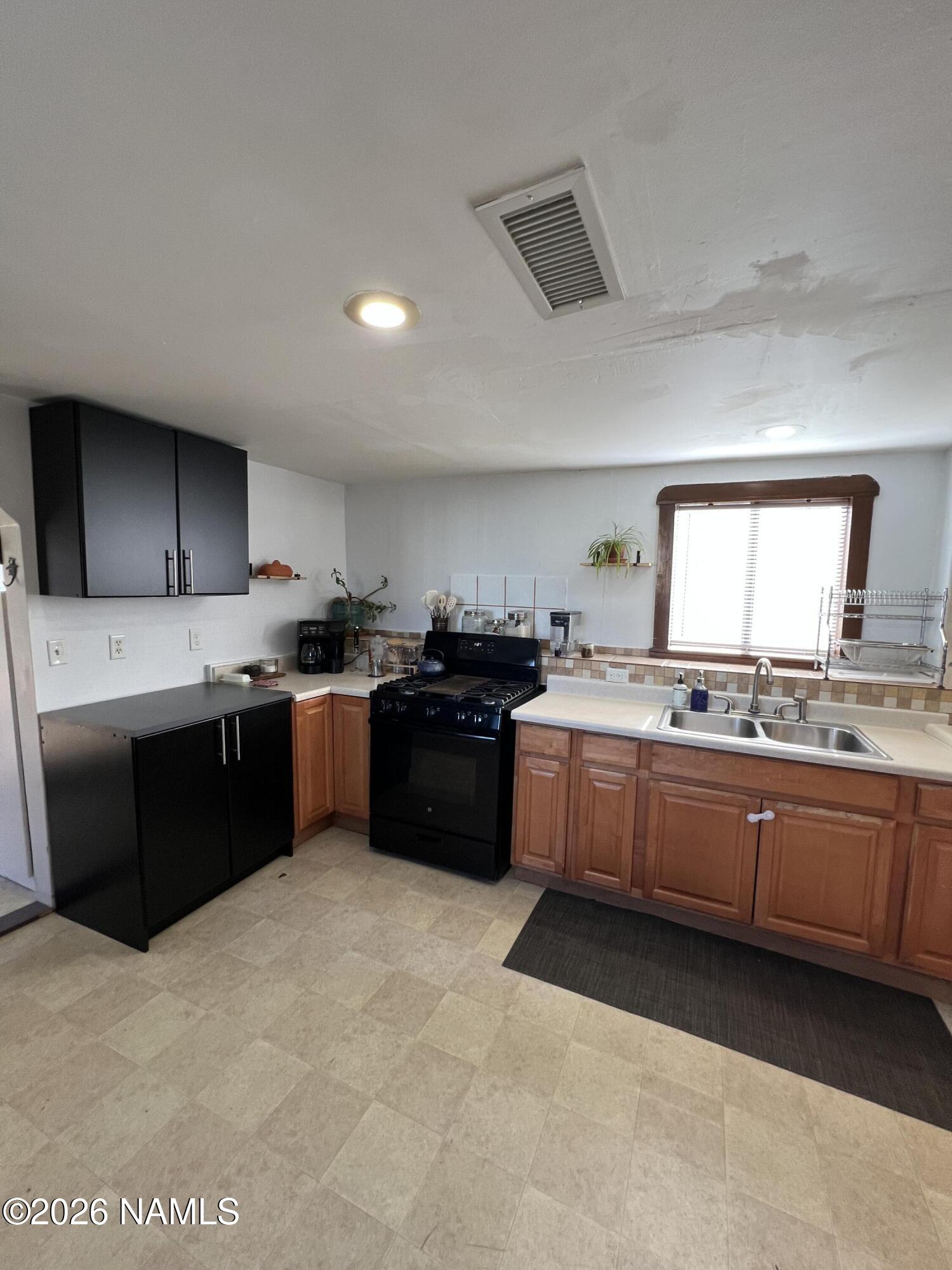 407 South 4th Street Williams, AZ 86046 - Photo 18 of 25 a kitchen with stainless steel appliances granite countertop a sink counter space and cabinets