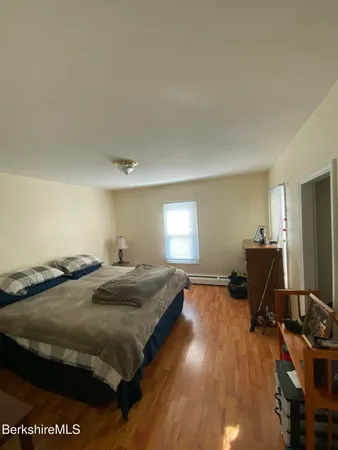 a bedroom with a bed and wooden floor