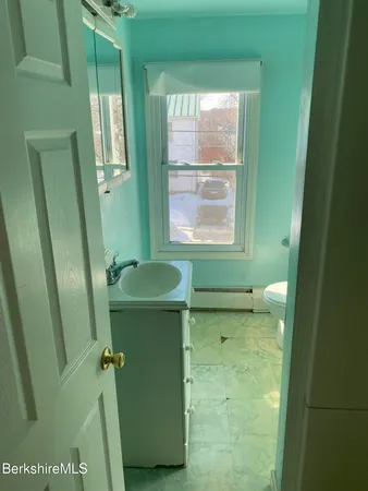 a bathroom with a sink a toilet and a mirror