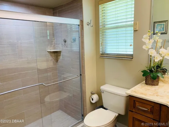 a bathroom with a granite countertop toilet a sink and shower