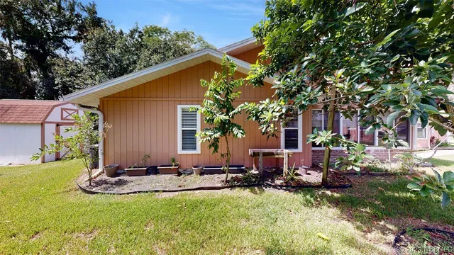 a view of a house with backyard sitting area and garden