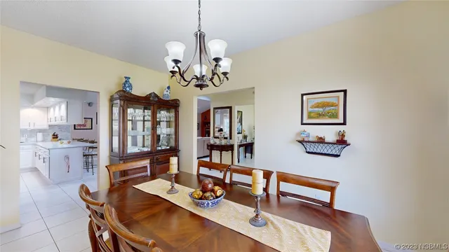 a dining room with wooden floor a chandelier a wooden table and chairs
