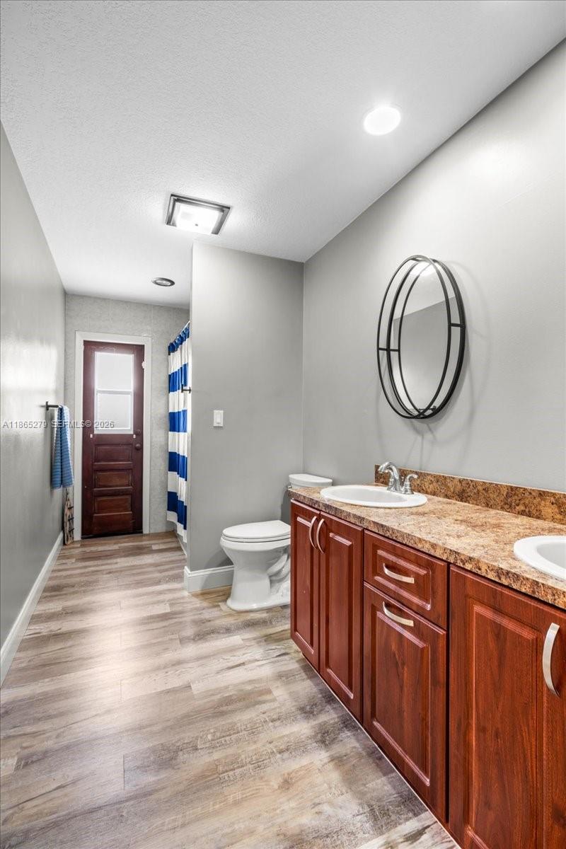 19926 Southwest 326th Street Homestead, FL 33030 - Photo 15 of 46 a spacious bathroom with a granite countertop sink a toilet and a mirror