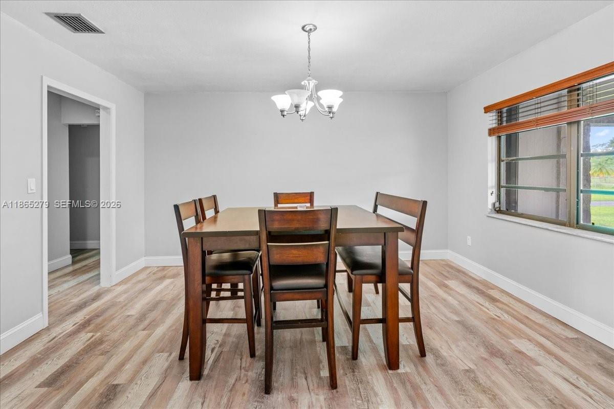 19926 Southwest 326th Street Homestead, FL 33030 - Photo 33 of 46 a dining room with furniture a chandelier and wooden floor