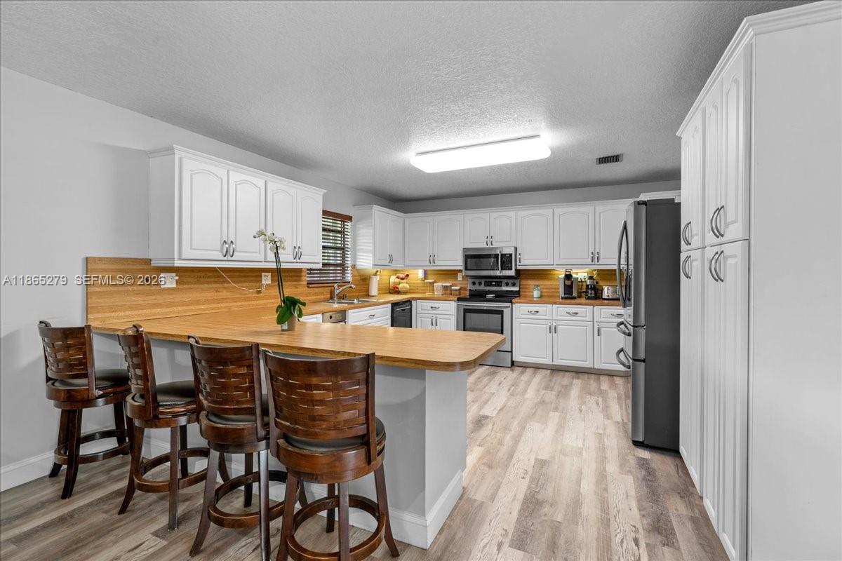 19926 Southwest 326th Street Homestead, FL 33030 - Photo 5 of 46 a kitchen with cabinets and chairs