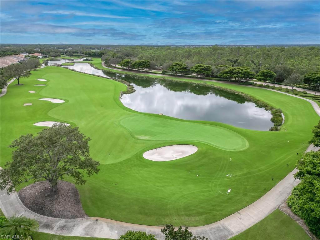 16881 Fairgrove Way, Unit 7102 Naples, FL 34110 - Photo 39 of 50 a view of a lake with a yard