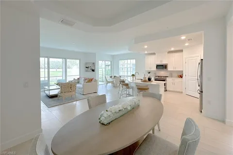 a living room with furniture white walls and kitchen view