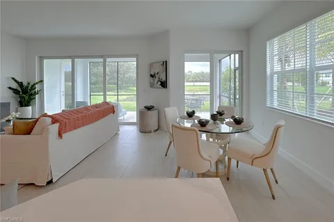 a living room with furniture and floor to ceiling windows