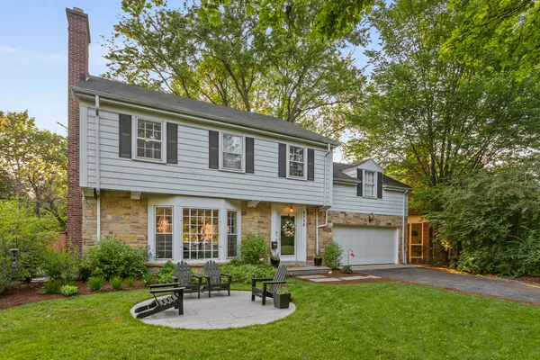 a front view of a house with a yard fire pit and outdoor seating