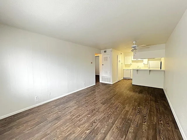 a view of a big room with wooden floor and windows