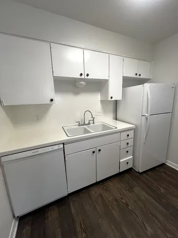 a kitchen with cabinets and a refrigerator