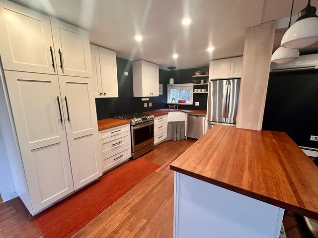 a kitchen with stainless steel appliances a stove a sink and a refrigerator