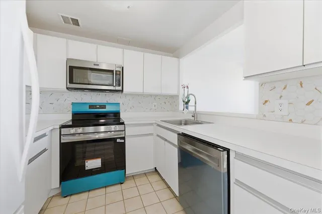 a kitchen with cabinets stainless steel appliances and a sink