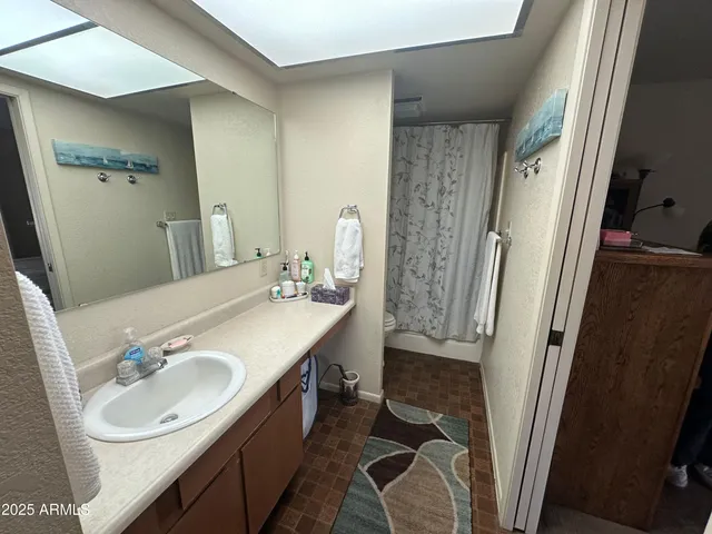 a bathroom with a sink a toilet a mirror and shower