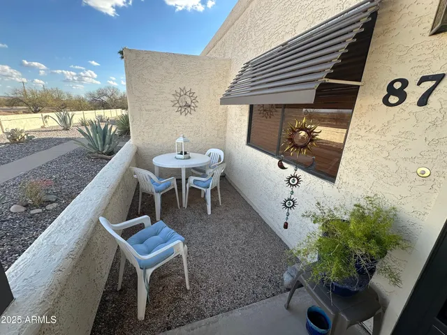 a roof deck with table and chairs potted plants with wooden floor