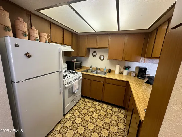 a kitchen with a refrigerator a stove top oven a sink and dishwasher