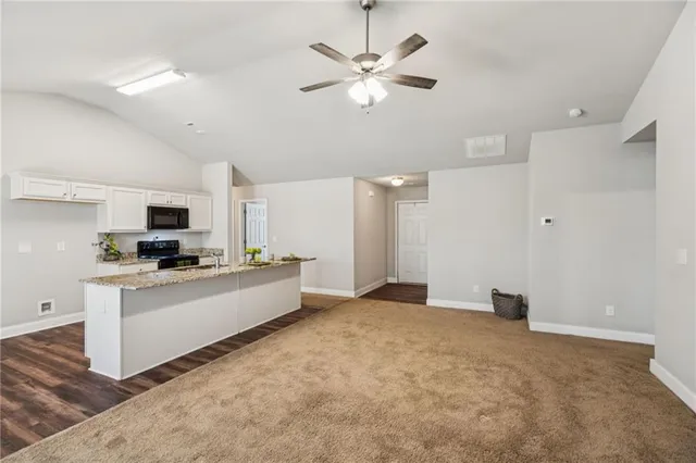 a living room with stainless steel appliances kitchen island furniture and a fireplace