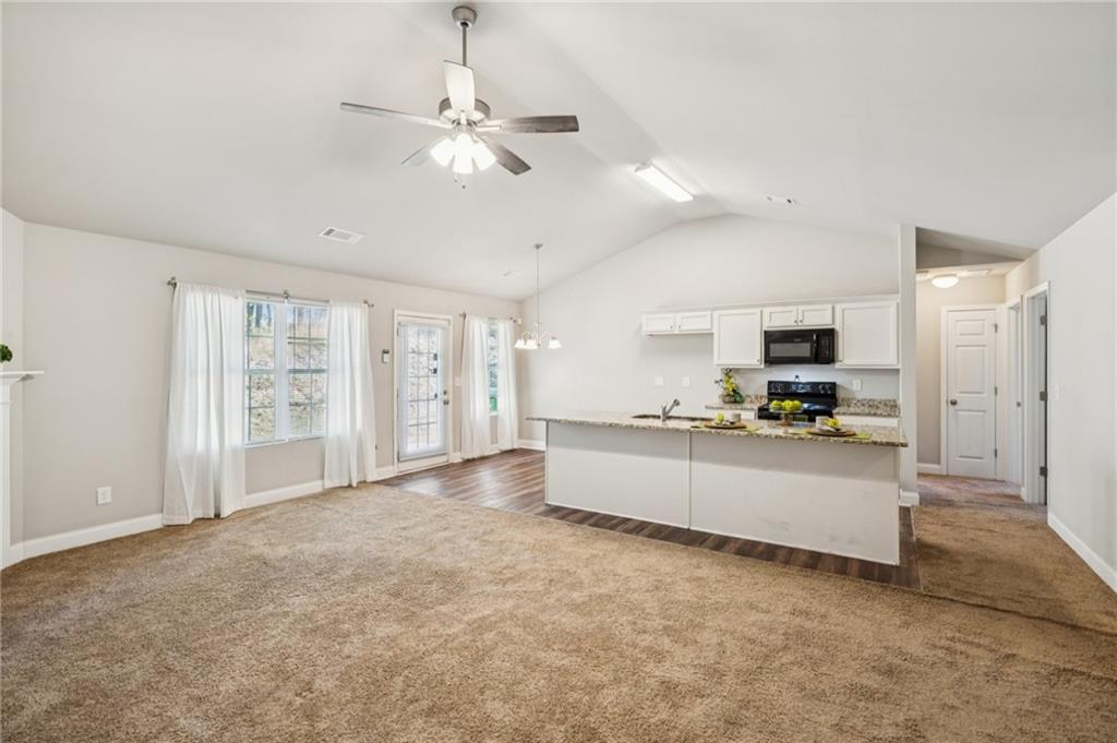 224 Katie Lane Commerce, GA 30529 - Photo 16 of 35 a large white kitchen with a large window a refrigerator and a sink