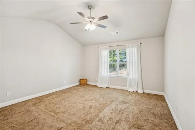 an empty room with fan and windows