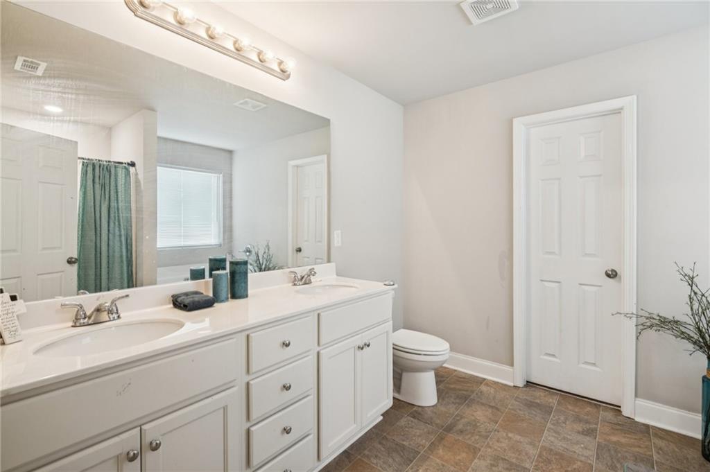 224 Katie Lane Commerce, GA 30529 - Photo 21 of 35 a bathroom with a double vanity sink a toilet and a mirror