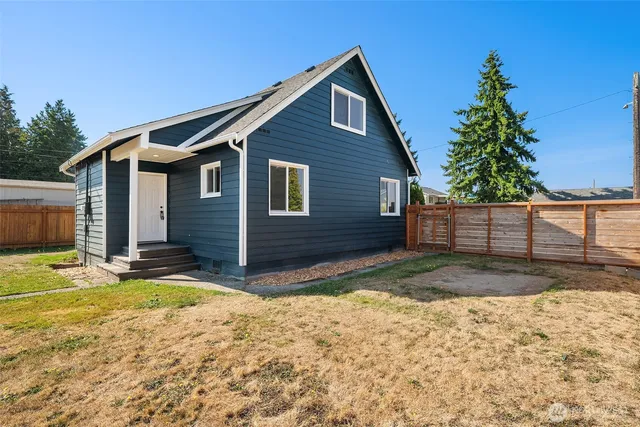 a view of a house with backyard and trees