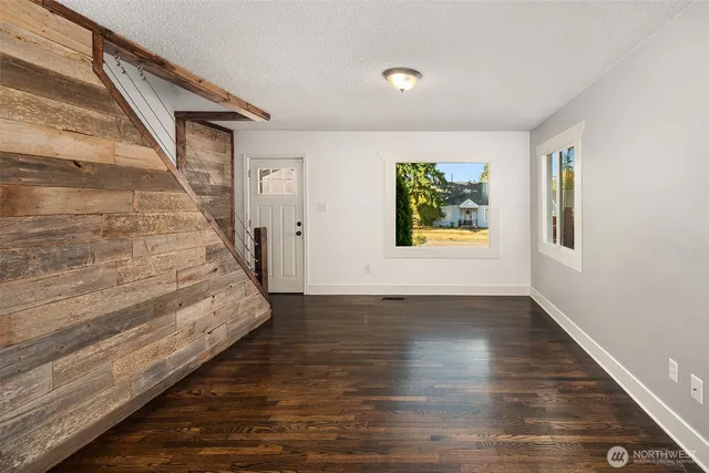 a view of a hallway with wooden floor and stairs