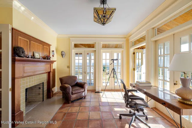 a living room with furniture a fireplace and a floor to ceiling window