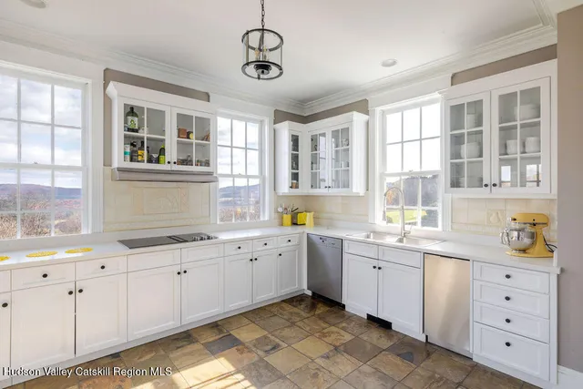 a kitchen that has a lot of cabinets in it and wooden floors