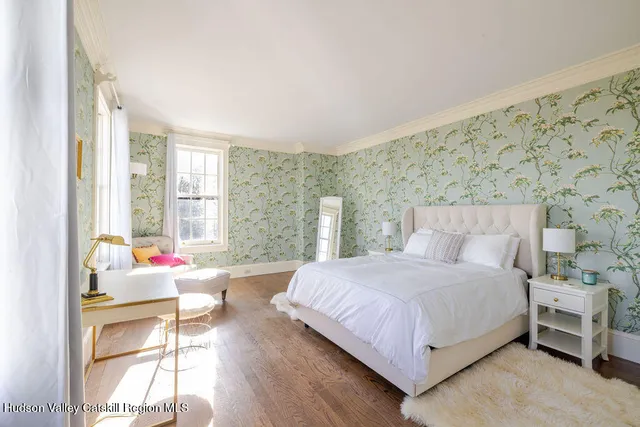 a bedroom with a bed and large windows