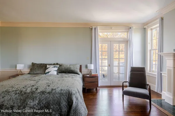a bedroom with a balcony a bed and a couch with wooden floor