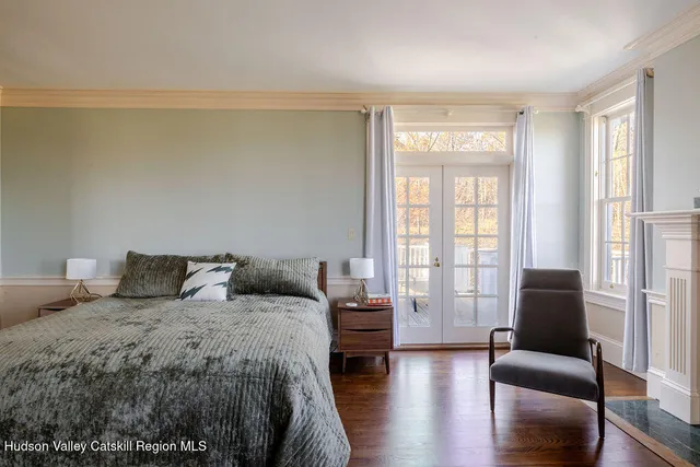 a bedroom with a balcony a bed and a couch with wooden floor