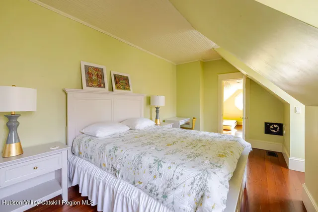 a bedroom with a bed and a lamp on dresser