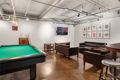 a room with furniture pool table and a window