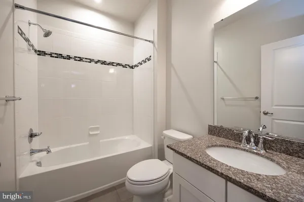 a bathroom with a granite countertop sink toilet mirror and shower