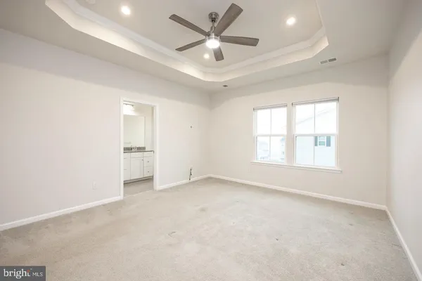 an empty room with a window and a ceiling fan