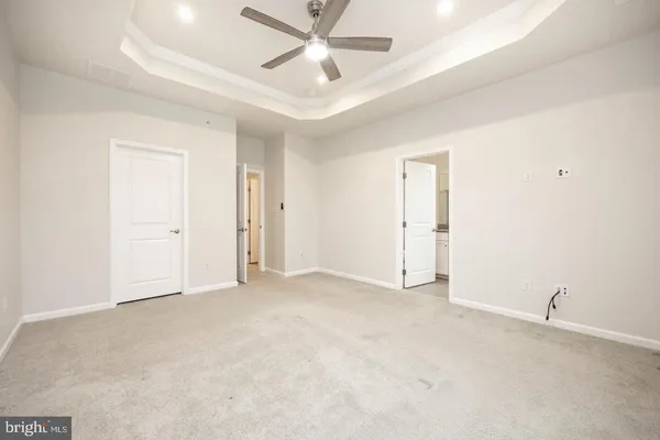 an empty room with closet and a ceiling fan