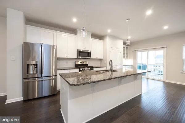 a kitchen with stainless steel appliances granite countertop a refrigerator a sink and a stove