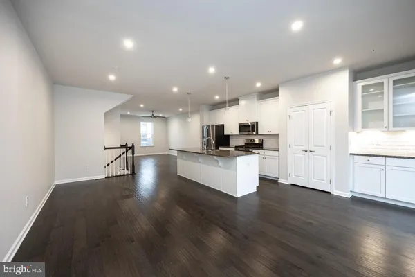 a view of kitchen with refrigerator stove and wooden floor