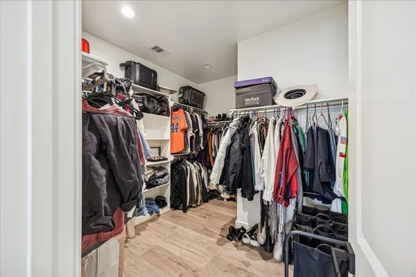 a view of walk in closet with clothes