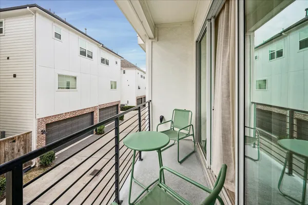 a balcony with table and chairs
