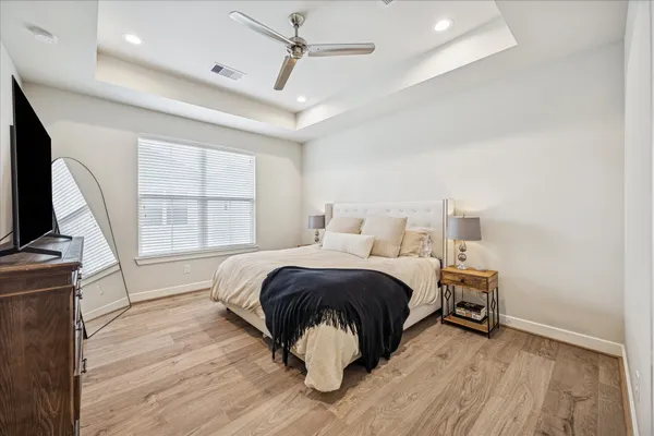 a bedroom with a bed and wooden floor