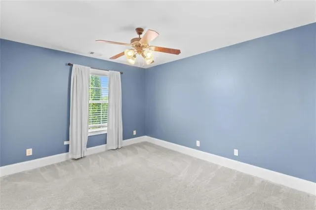 a view of an empty room with a ceiling fan
