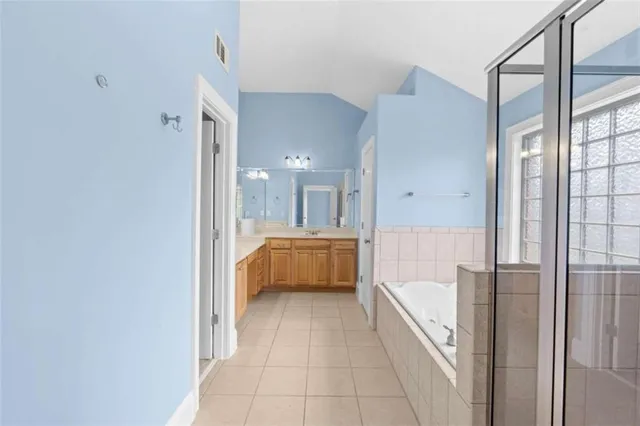 a bathroom with a tub a window and a shower