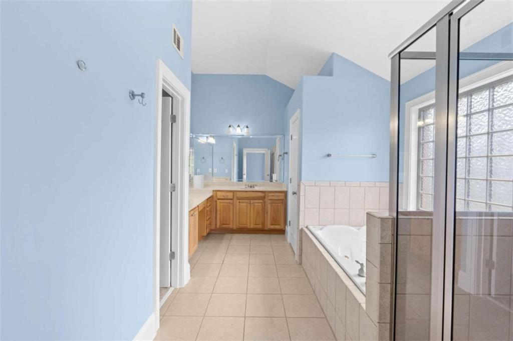 4201 Donington Way Hampton, GA 30228 - Photo 34 of 43 a bathroom with a tub a sink and a large mirror